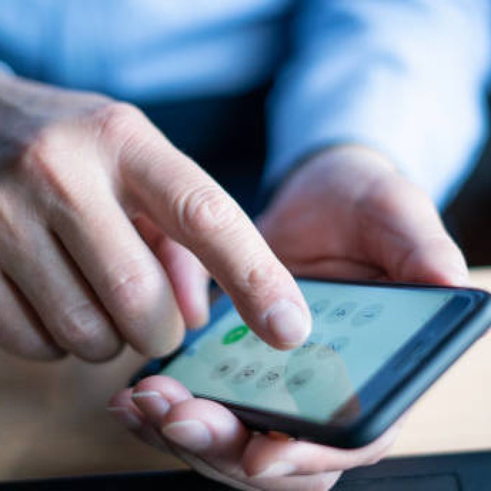 businessman writes phone number , using smartphone